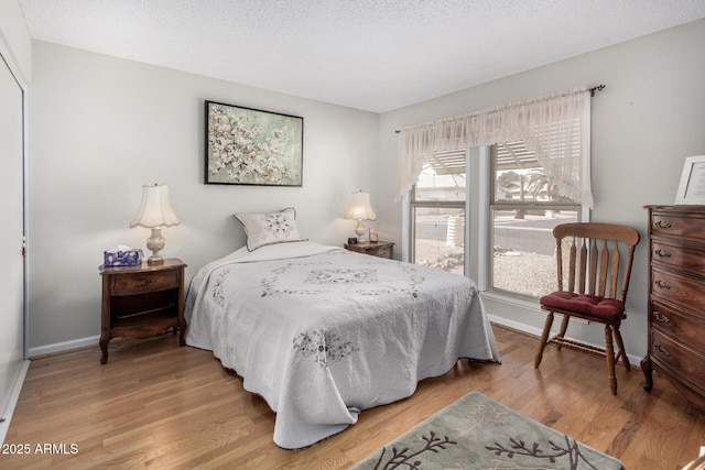 bedroom featuring wood-type flooring and a textured ceiling