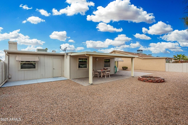 back of property with a patio area and an outdoor fire pit