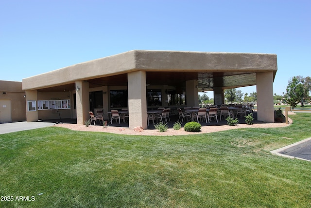 back of property featuring ceiling fan and a lawn