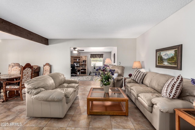 living room with ceiling fan, beam ceiling, and a textured ceiling