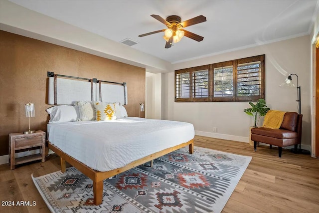 bedroom with ceiling fan, crown molding, and hardwood / wood-style flooring