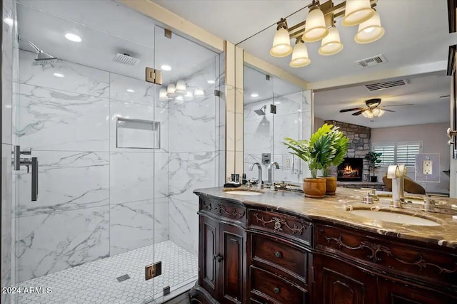 bathroom featuring a fireplace, vanity, an enclosed shower, and ceiling fan