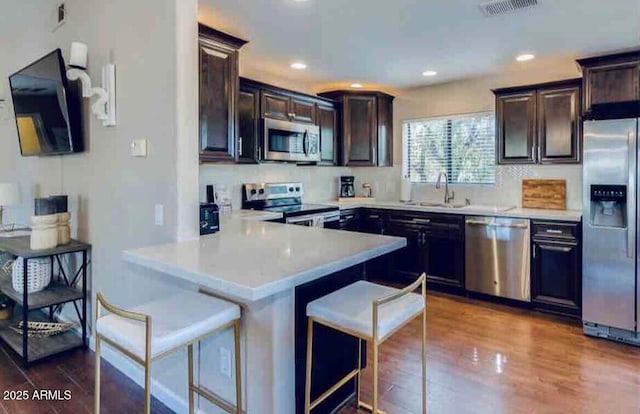 15252 N 100th St Unit 2157, Scottsdale, AZ 85260 - kitchen with appliances with stainless steel finishes, a kitchen bar, a sink, light countertops, and dark brown cabinets