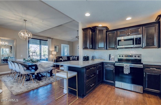 15252 N 100th St Unit 2157, Scottsdale, AZ 85260 - kitchen featuring appliances with stainless steel finishes, open floor plan, a chandelier, light countertops, and a peninsula