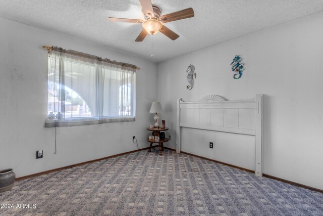 spare room with a textured ceiling, ceiling fan, and carpet floors