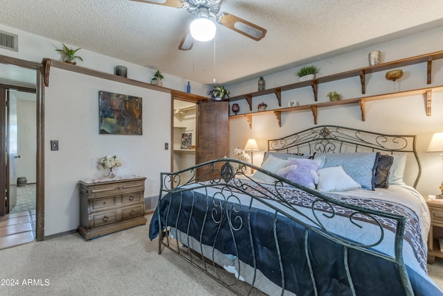 carpeted bedroom with a textured ceiling and ceiling fan