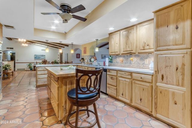 kitchen featuring decorative light fixtures, ceiling fan, kitchen peninsula, a breakfast bar area, and tasteful backsplash