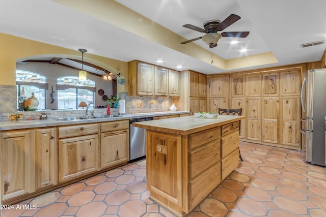 kitchen featuring hanging light fixtures, a center island, appliances with stainless steel finishes, sink, and decorative backsplash