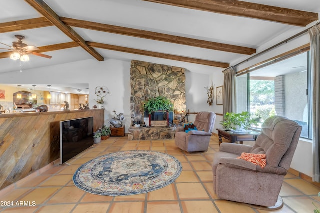 tiled living room featuring a fireplace, ceiling fan, and vaulted ceiling with beams