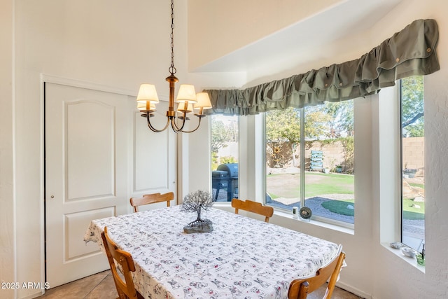 dining space with tile patterned flooring and a chandelier