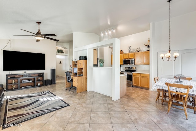 kitchen featuring vaulted ceiling, ceiling fan with notable chandelier, decorative light fixtures, light tile patterned floors, and stainless steel appliances