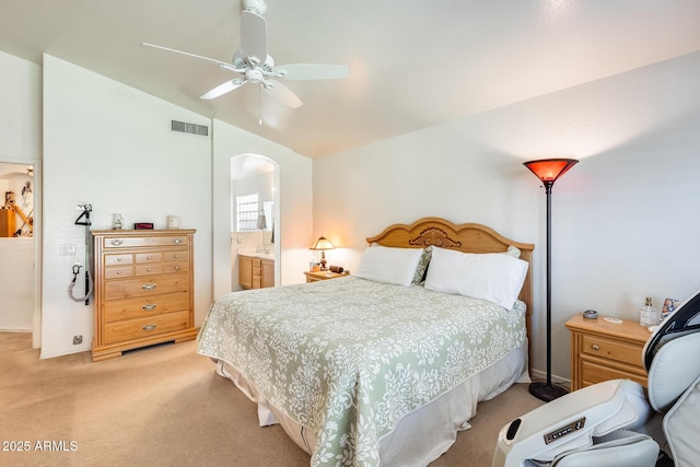 bedroom with vaulted ceiling, light carpet, ceiling fan, and ensuite bath