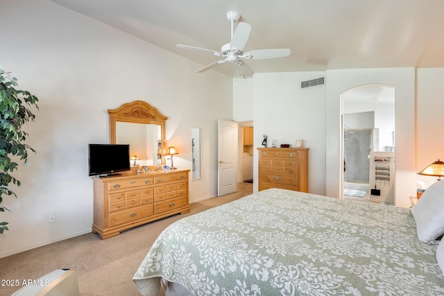 bedroom featuring light colored carpet, lofted ceiling, and connected bathroom