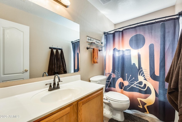 bathroom with vanity, curtained shower, and toilet