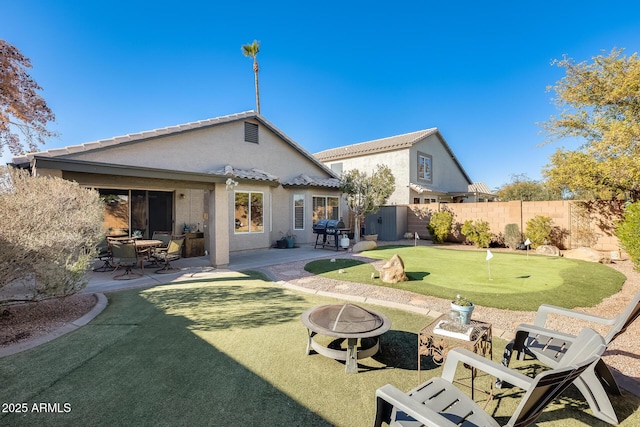 back of house with an outdoor fire pit and a patio area