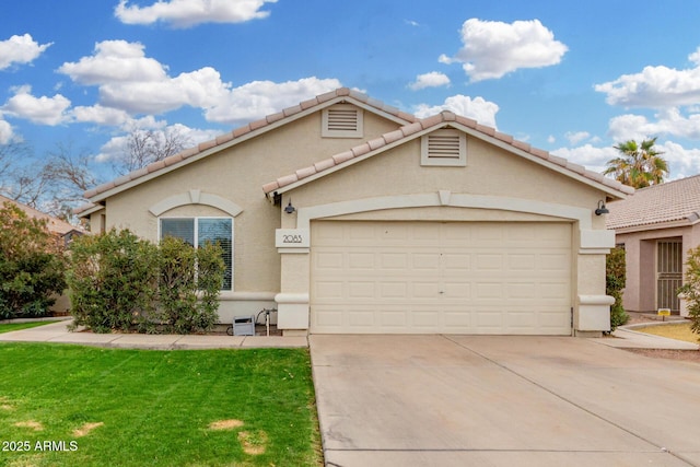 view of front facade featuring a tile roof, stucco siding, an attached garage, a front yard, and driveway