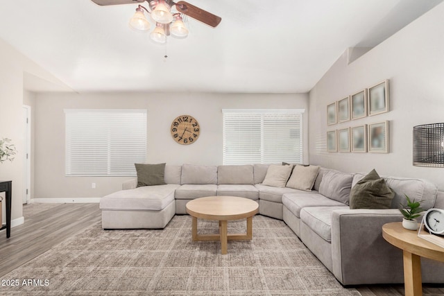 living area with a ceiling fan, light wood-style flooring, and baseboards