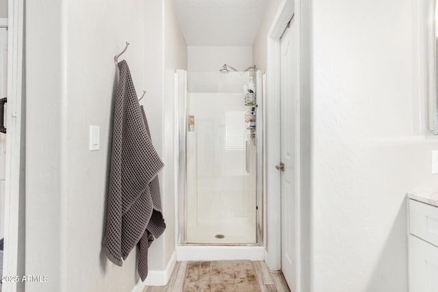 bathroom with a shower stall and vanity