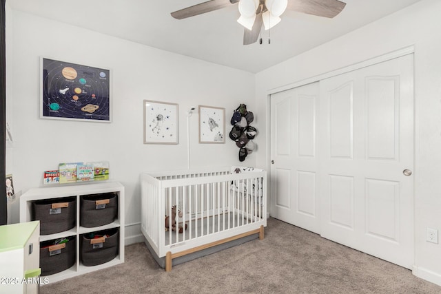 bedroom with carpet floors, a nursery area, a closet, and a ceiling fan