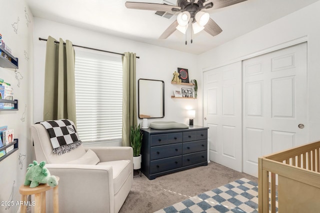 bedroom featuring ceiling fan, light colored carpet, visible vents, a closet, and a crib