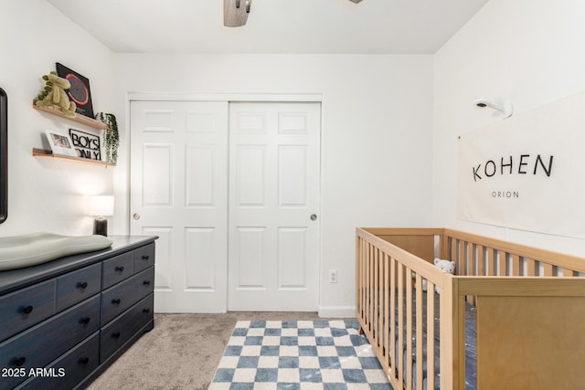 bedroom featuring carpet, a closet, and a nursery area