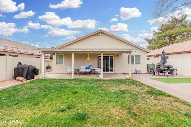 rear view of property featuring a fenced backyard, a patio, a lawn, and stucco siding