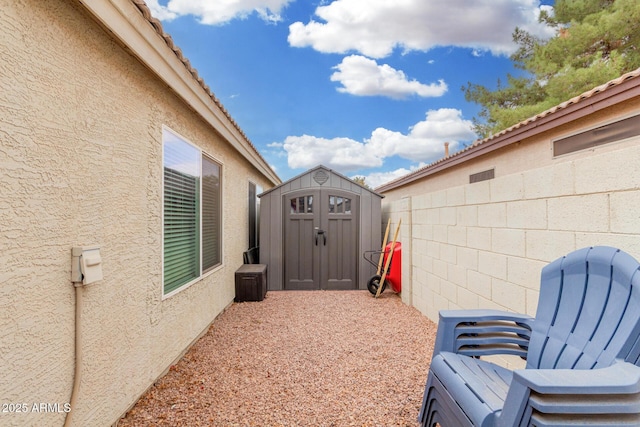 exterior space featuring a storage shed, fence, and an outbuilding