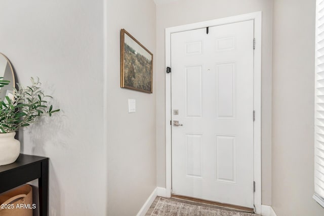 doorway featuring baseboards