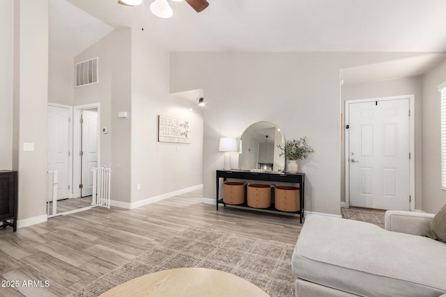 living room featuring light wood-type flooring, visible vents, and baseboards