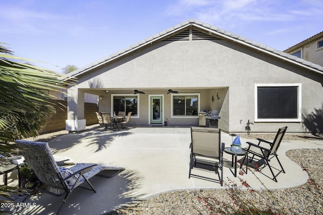 rear view of property with a patio area, ceiling fan, fence, and stucco siding