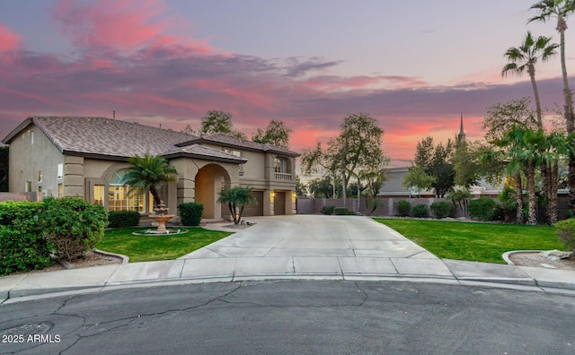 mediterranean / spanish house featuring a yard and a garage