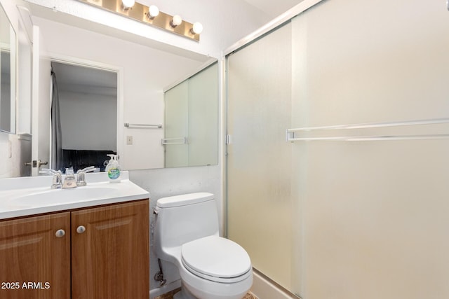 bathroom with toilet, a shower stall, and vanity