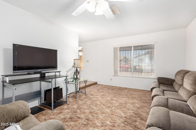 living room with ceiling fan, carpet floors, a textured ceiling, and visible vents