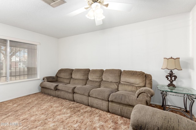 living room featuring a textured ceiling, ceiling fan, and visible vents