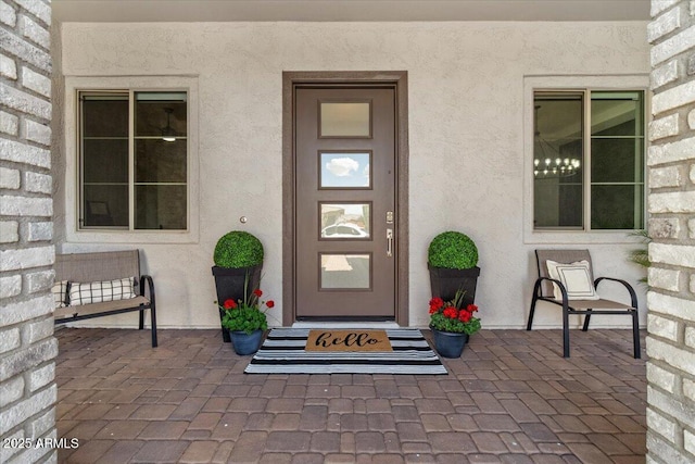 doorway to property featuring stucco siding
