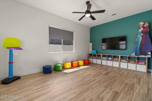 game room with visible vents, a ceiling fan, baseboards, and wood finished floors