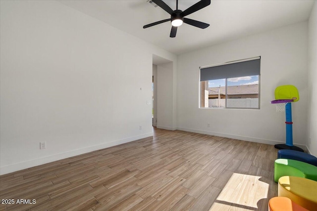 empty room with baseboards, ceiling fan, and wood finished floors