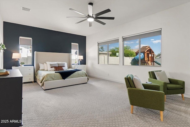 carpeted bedroom featuring baseboards, a ceiling fan, and visible vents