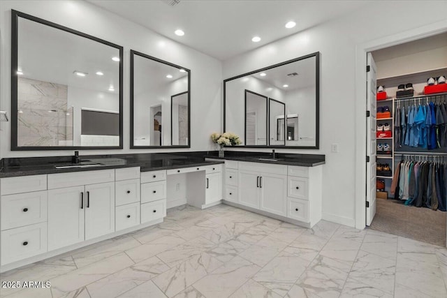 bathroom featuring recessed lighting, a walk in closet, marble finish floor, and vanity