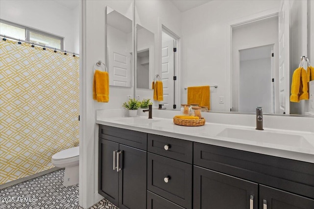 full bathroom featuring a sink, curtained shower, toilet, and double vanity