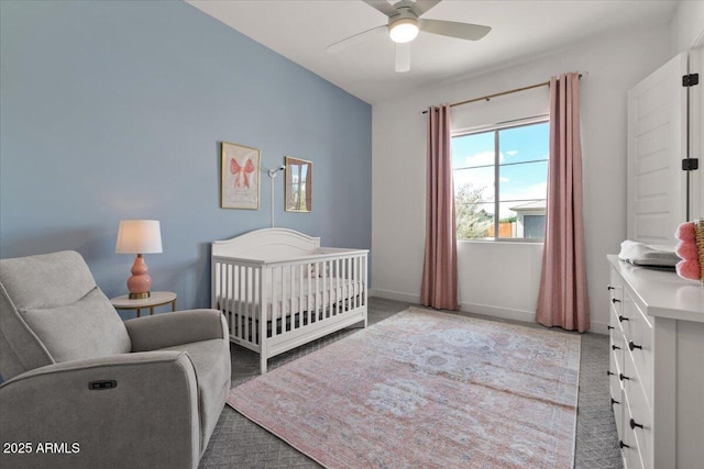 bedroom featuring baseboards, ceiling fan, light carpet, and a crib