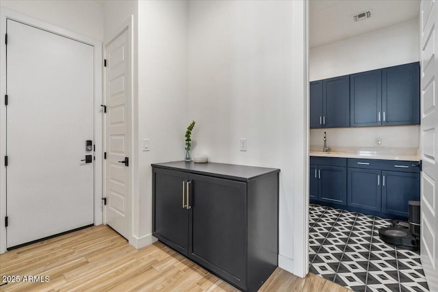 interior space featuring visible vents, a sink, and light wood-style flooring