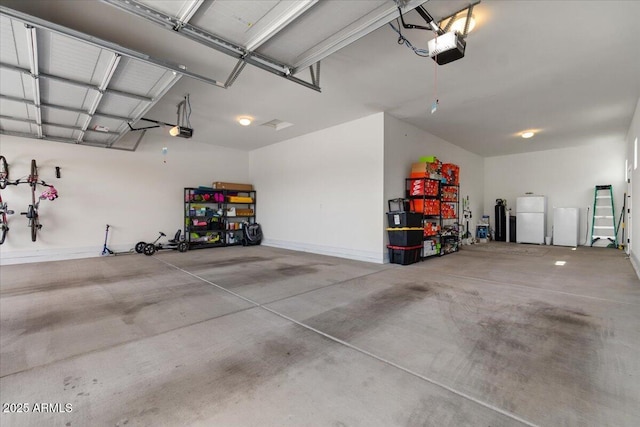 garage with freestanding refrigerator and a garage door opener