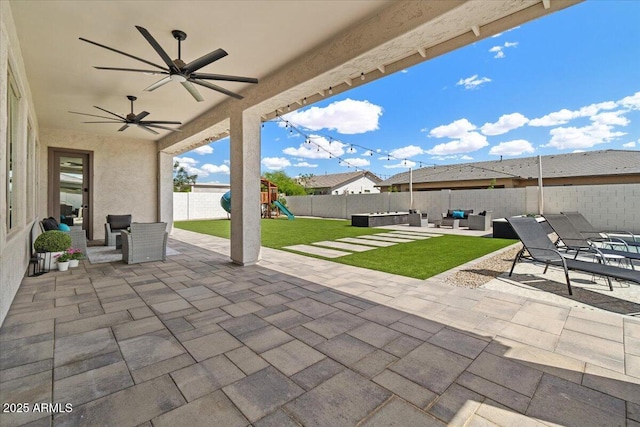 view of patio / terrace featuring ceiling fan, a fenced backyard, an outdoor hangout area, and a playground