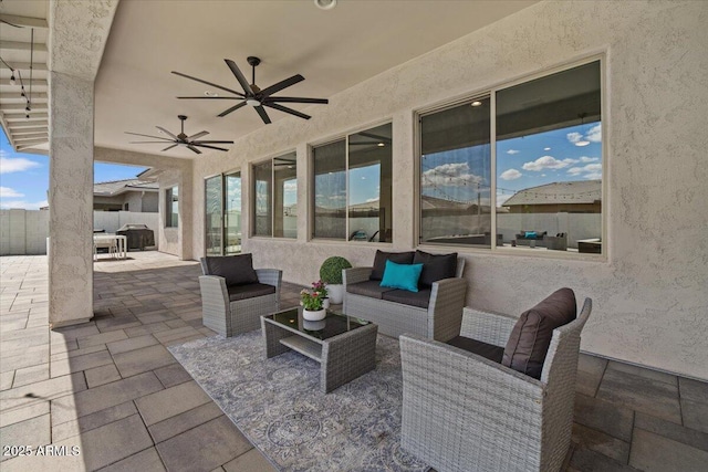 view of patio with fence, a ceiling fan, and outdoor lounge area
