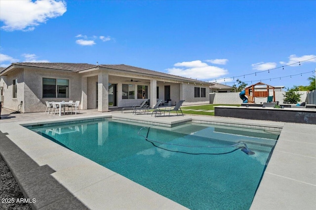 view of swimming pool with a patio, a fenced in pool, a ceiling fan, and a playground