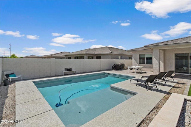 view of swimming pool featuring a fenced in pool, a fenced backyard, and a patio area