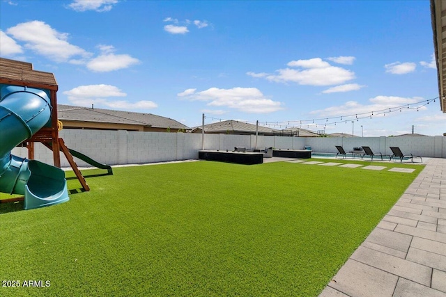 view of yard featuring a fenced backyard, outdoor lounge area, a playground, and a patio area