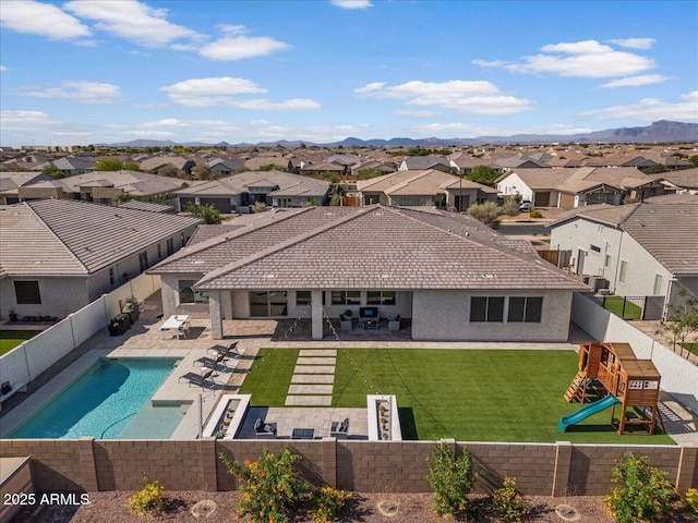 exterior space featuring a fenced backyard, a patio area, a playground, and a residential view
