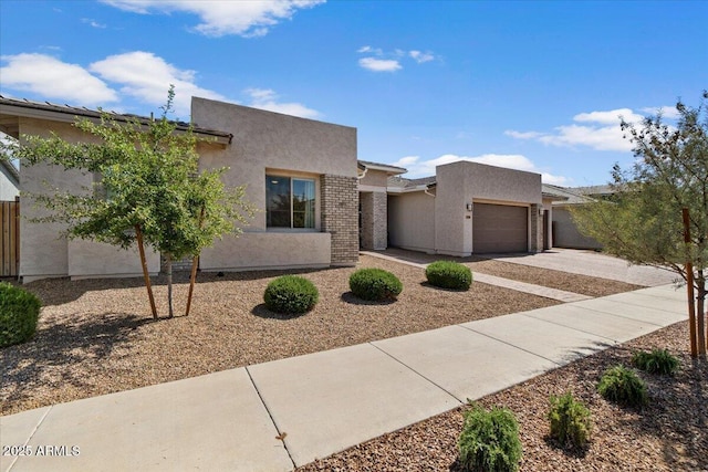 adobe home featuring stucco siding, driveway, and a garage
